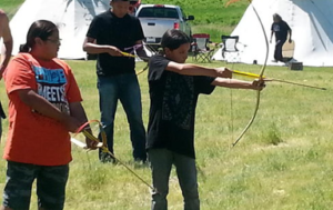 LYD youth practicing loading and aiming bow and arrow
